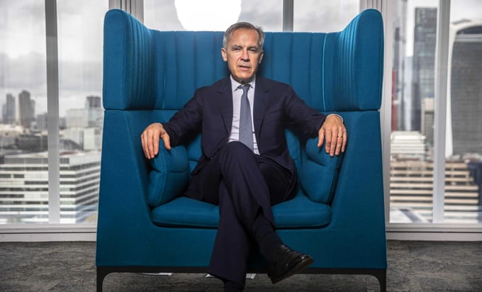 Mark Carney sitting on a large blue armchair, looking rather regal
